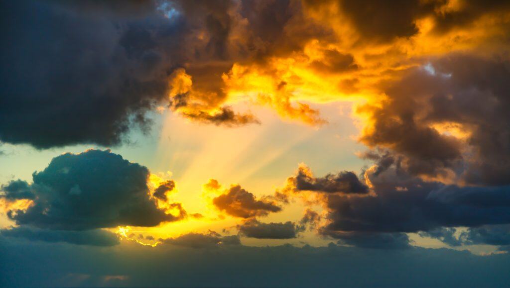 Sunlight breaking through storm clouds, visually reflecting the question Is God real and symbolizing the hope of divine reality in a dark and searching world.