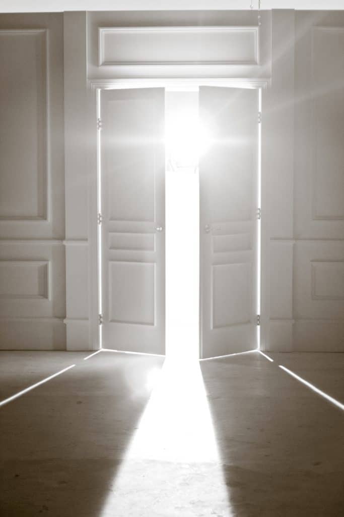 Light piercing a dark doorway, symbolizing the choice behind the question Is God real?—a call to turn from darkness and find mercy.


