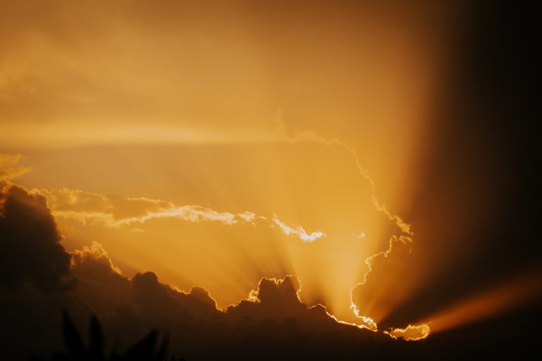 Sunlight breaking through storm clouds, visually reflecting the question Is God real? and symbolizing the hope of divine reality in a dark and searching world.