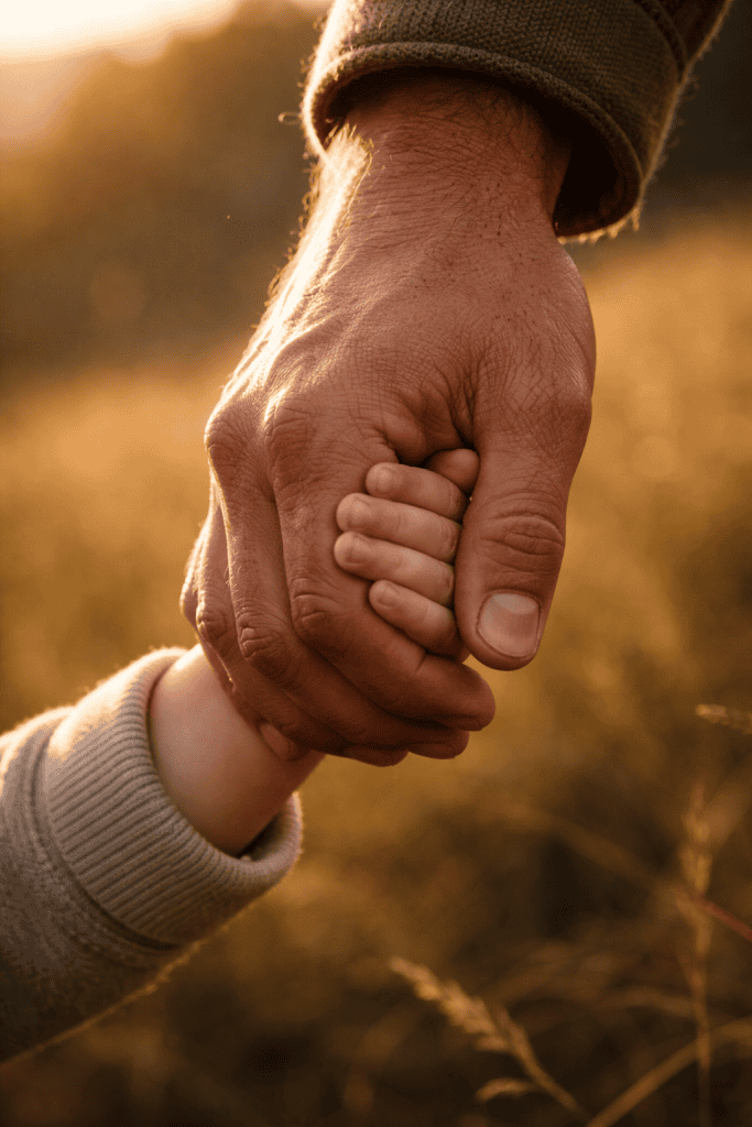 Father's hand holding child's hand representing the perseverance of the saints and God's keeping power in salvation
